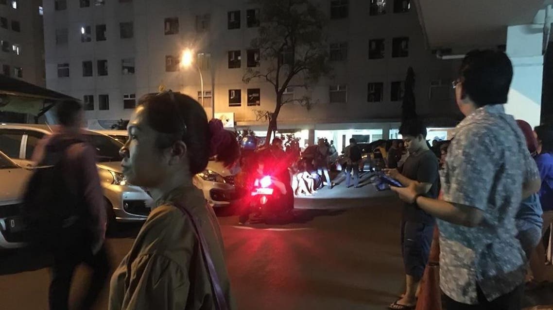 Resident stand outside an apartment block after a strong earthquake hit the area around Jakarta on August 2, 2019. (AFP)