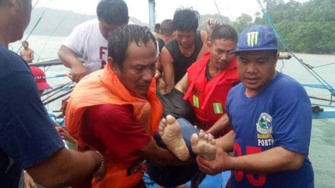 A handout photo from the Philippines Coastguard taken on August 3, 2019, shows fishermen carrying a dead body after a boat accidents that happened in Iloilo-Guimaras Strait. (AFP)