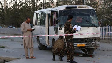 Afghan security personnel investigate a damage bus carrying employees of Khurshid TV, at the site of a sticky bomb blast in Kabul on August 4, 2019. (AFP)