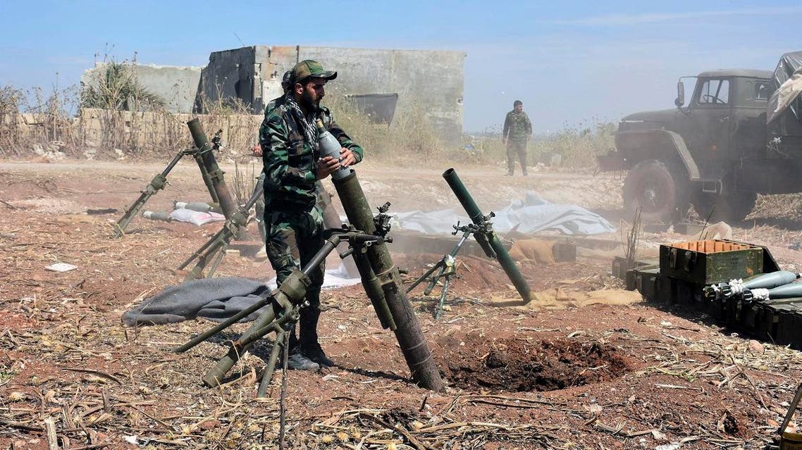 Syrian army soldiers prepare to launch a mortar towards insurgents in the village of Kfar Nabuda, in the countryside of Hama province. (AP)