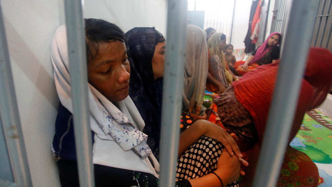 In this June 12, 2019, file photo, Rohingya refugees sit behind bars at a police station in Satun province, southern Thailand after Thai officials say they have discovered 65 ethnic Rohingya Muslim refugees who were shipwrecked and stranded in southern Thailand. (AP)