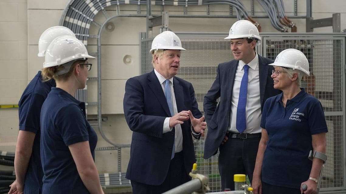 Britain’s Prime Minister Boris Johnson (C) meets staff during his visit to the Fusion Energy Research Centre at the Fulham Science Centre in Oxfordshire, south east England on August 8, 2019. (AP)