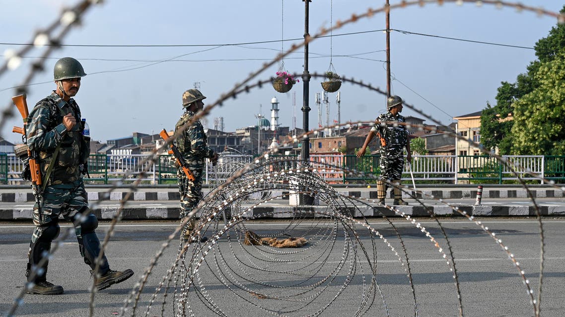 In this photo taken on August 5, 2019, Indian paramilitary troopers stand guard near a barbed fence wire as they block a road during a curfew in Srinagar. (AFP)