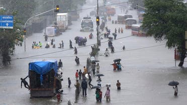 People walk through a flooded street following heavy monsoon rains in Mumbai, India. India's monsoon season runs from June to September. (AP)