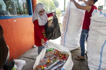 This picture shows passengers exchanging plastic bottles for Suroboyo bus tickets at a terminal in the Indonesian city of Surabaya. (AFP)