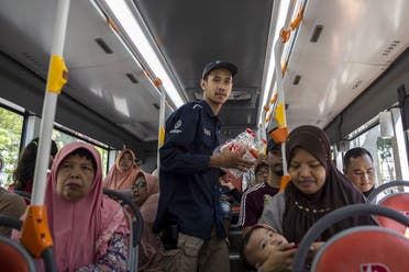 This picture shows a bus conductor collecting used plastic bottles as fare payment on board a Suroboyo bus in the Indonesian city of Surabaya. (AFP)