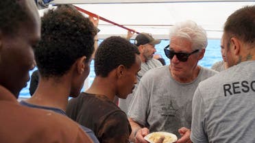 Actor Richard Gere (right) helps serving meals to migrants aboard the Open Arms Spanish humanitarian boat as it cruises in the Mediterranean Sea, on August 9, 2019. (AP)