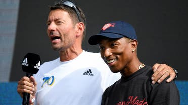 Adidas CEO Kasper Rorsted speaks next to singer Pharrell Williams as they attend the celebrations for Adidas’ 70th anniversary at the company’s headquarters in Herzogenaurach, Germany, on August 9, 2019. (Reuters)