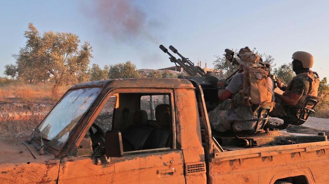 Fighters from the former al-Qaeda Syrian affiliate Hayat Tahrir al-Sham (HTS) fire an anti-aircraft gun mounted on a pickup truck in Syria's southern Idlib province on August 7, 2019. (AFP)