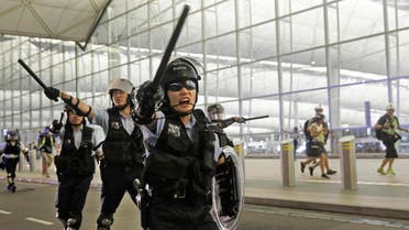 Policemen with batons and shields shout at protesters during a demonstration at the Airport in Hong Kong, Tuesday, Aug. 13, 2019.  (AP)