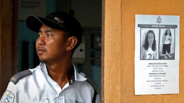 A security guard stands next to a notice showing a missing British girl in Seremban, Malaysia, Sunday, Aug. 11, 2019. (AP)