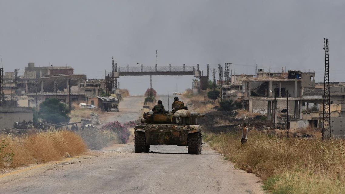 A tank belonging to the Syrian regime forces drives on a road in Hama. (AFP)