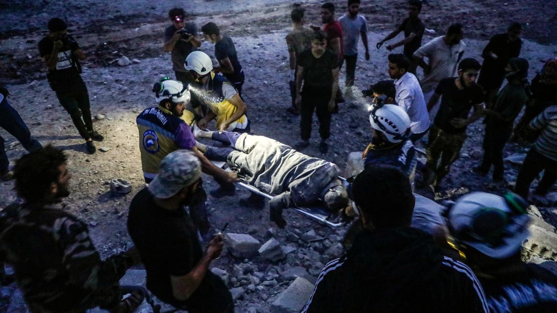 Members of the Syrian Civil Defence, also known as the White Helmets, carry away on a stretcher a man rescued from the rubble of a collapsed building following a reported air strike in Kfar Ruma in Syria's northwestern Idlib province, on August 16, 2019. Air strikes on August 16 by Syria's regime and its Russian ally killed 15 civilians in the area controlled by Syria's former Al-Qaeda affiliate Hayat Tahrir al-Sham (HTS) in Idlib province, said the Britain-based Syrian Observatory for Human Rights. The strikes came as regime forces battled HTS jihadists and allied rebels in the region, where fierce fighting claimed the lives of 13 loyalists and 18 jihadists and allied rebels, the Observatory said.