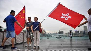 Pro-government supporters pose with the Hong Kong flag (R) and China national flag during a rally at Tamar Park in Hong Kong on August 17, 2019. (AFP)