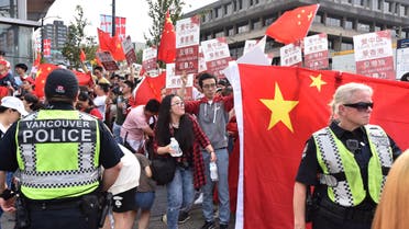 Vancouver police officers keep Pro-China supporters away from pro-Hong Kong supporters during a demonstration for both pro and against extradition law changes in Hong Kong in Vancouver, Canada. (AFP)