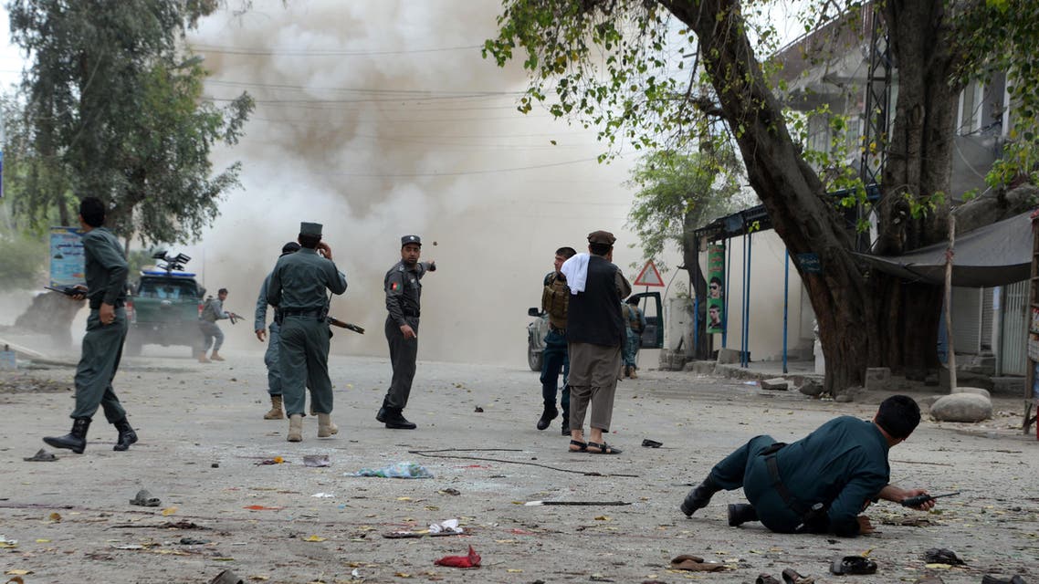 Afghan security personnel look on after a second explosion following a suicide attack outside a bank in Jalalabad on April 18, 2015. (AFP)