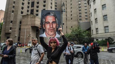 A member of a protest group holds up a sign of Jeffrey Epstein in front of the Metropolitan Correction Center on July 8, 2019 in New York City. (AFP)