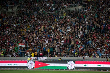 Iraqi football fans cheer as they watch the international friendly football match between Iraq and Syria at Basra Sports City Stadium on March 20, 2019. (AFP)