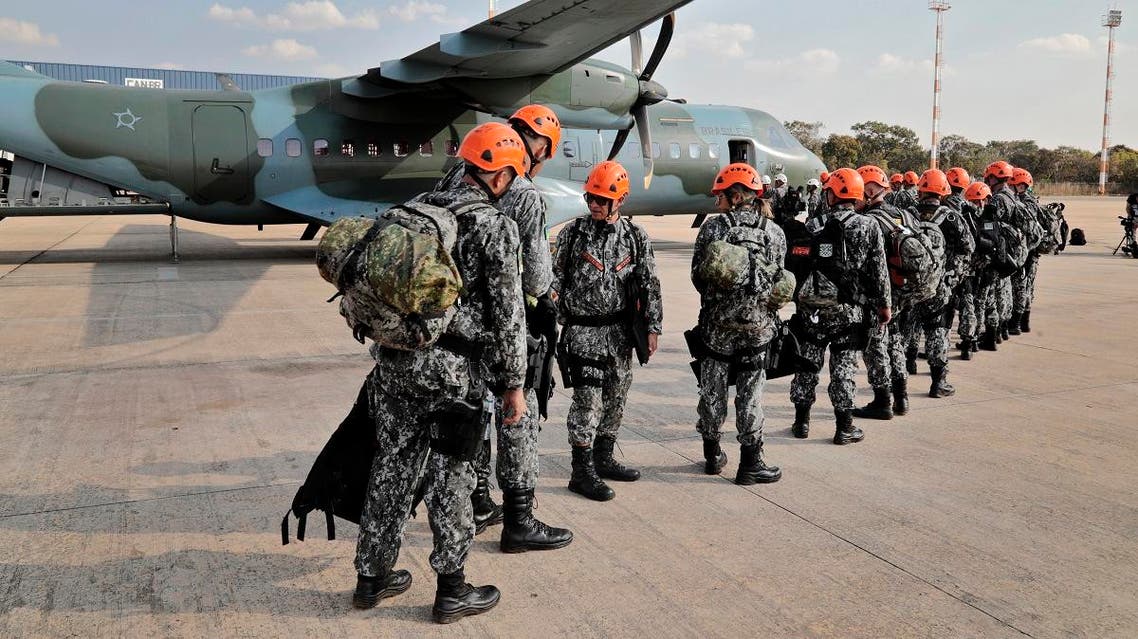 National Force military firefighters stand in line to board a plane to Rondonia northern Brazil, to help fight fires in the Amazon rainforest at the Military Air Base in Brasilia, on August 24, 2019. (AFP)