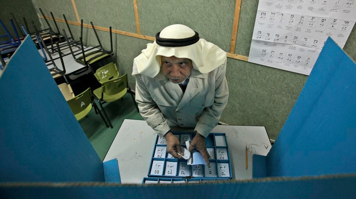 Israeli Arab Abdullah Talash, 74, chooses his ballot in order to vote in Israel's general election at a polling station. (File photo: AP)