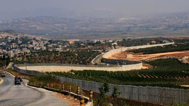 A photograph taken from near the southern Lebanese village of Adaiseh shows vehicles driving along the border wall with Israel. afp