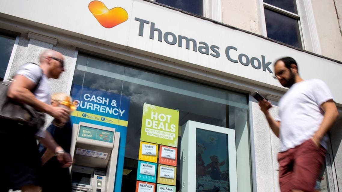 Pedestrians walk past a branch of a Thomas Cook travel agent's shop in London. (File photo: AFP)