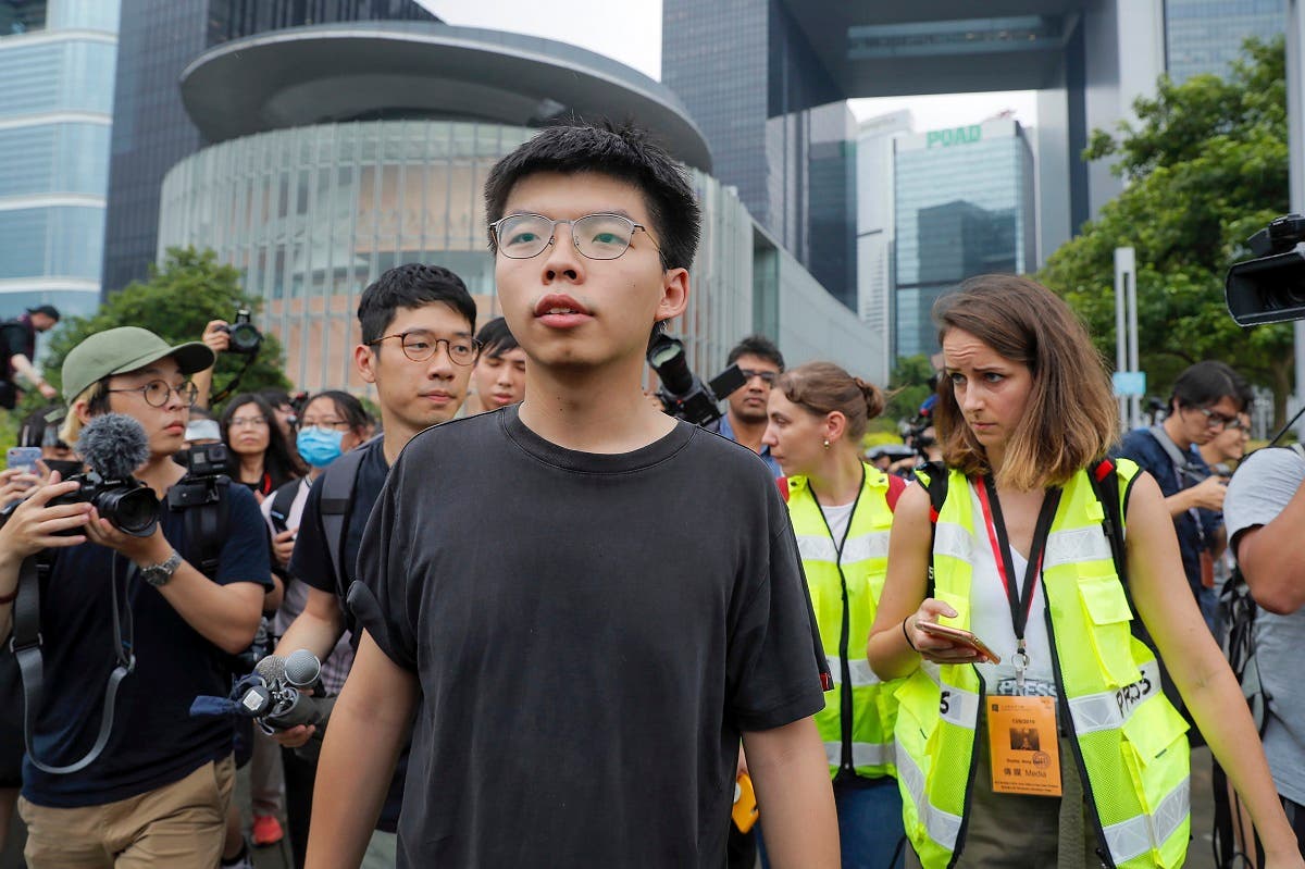 Pro-democracy activist Joshua Wong (center), is chased by reporters after he speaks to protesters near the Legislative Council in Hong Kong. (File photo: AP)