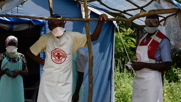 Health workers stand at a non-gazetted crossing point in the Mirami village, near the Mpondwe border check point between Uganda and the Democratic Republic of Congo on June 14, 2019. (AFP)