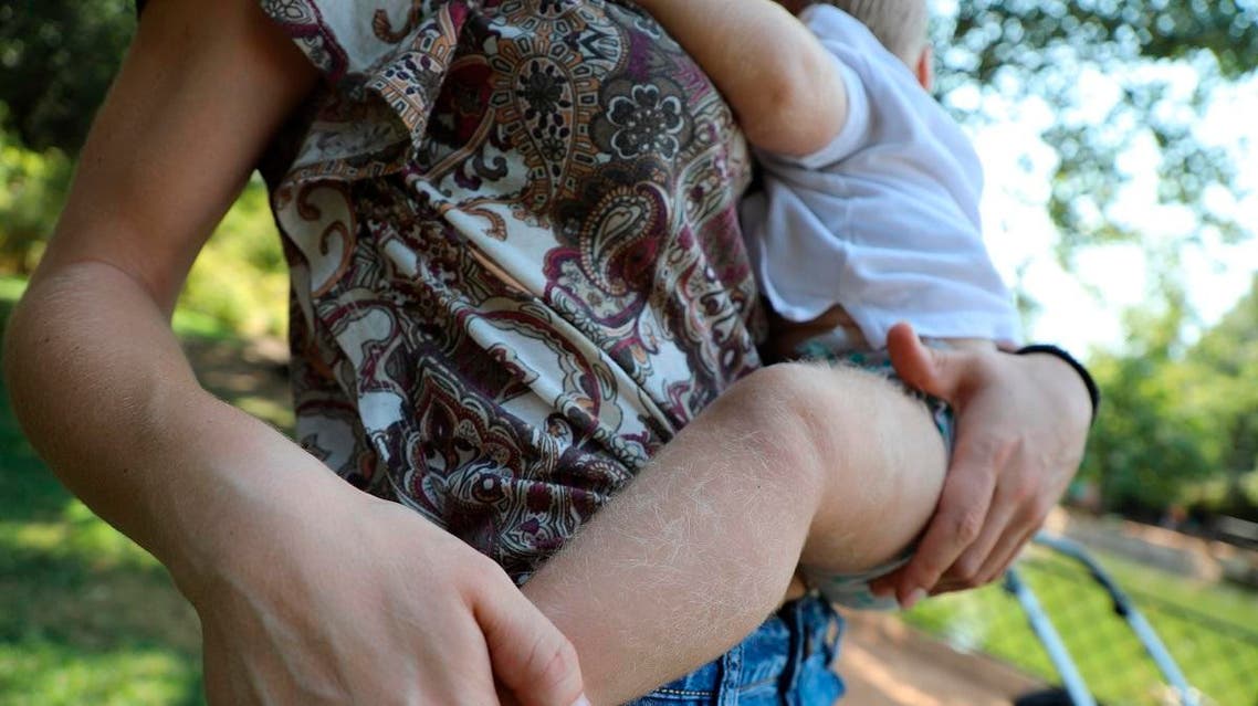 A baby carried by his mother affected by the drug mix-up. (AP)