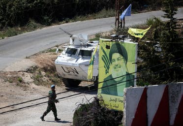 A UN peacekeeper of the United Nations Interim Force in Lebanon (UNIFIL) walks near a poster depicting Lebanon's Hezbollah leader Hassan Nasrallah in Adaisseh. (AFP)