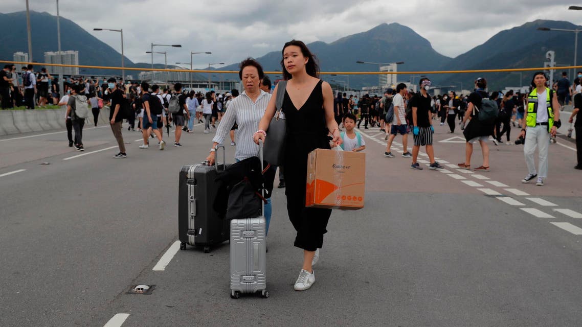 Passengers walk to airport as pro-democracy protestors blocked a road outside the airport in Hong Kong, Sunday, Sept.1, 2019. (AP)