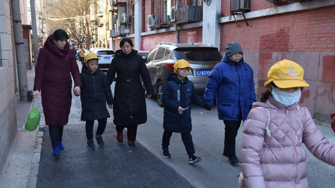 Parents and family members escort their children from an elementary school where an attack took place in Beijing on January 8, 2019. (AFP)