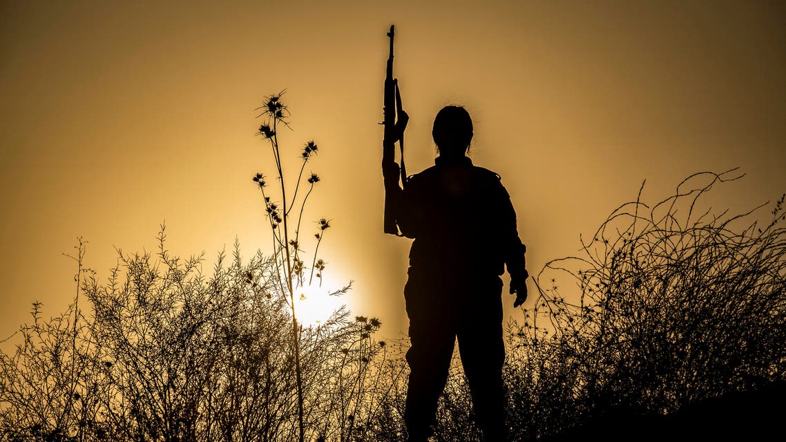 A member of the Bethnahrin Women Protection Forces (HSNB), an all-female Syriac-Assyrian paramilitary group under the umbrella of the Syrian Democratic Forces (SDF), stands holding up a Kalashnikov assault rilfe during a commemoration of the fourth anniversary of their creation, in the countryside of the town of Tall Tamr in the northwestern Syrian province of Hasakah, on August 30, 2019.