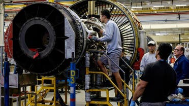 Men work with a jet engine at General Electric (GE) Celma, GE’s aviation engine overhaul facility in Petropolis, Rio de Janeiro, Brazil. (AFP)