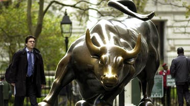 A man walks past the charging bull statue near the New York Stock Exchange. The charging bull is a symbol of a strong stock market. (AFP)