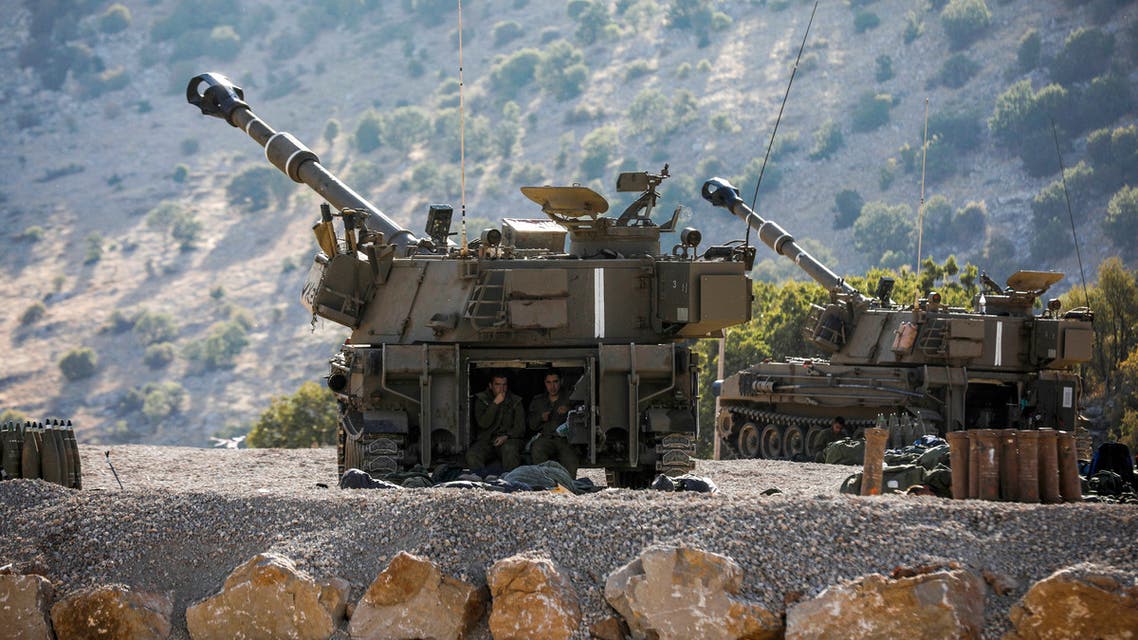 Israeli soldiers sit in the back of a self-propelled artillery gun positioned along the border with Syria in the the Israeli-annexed Golan Heights on August 25, 2019.