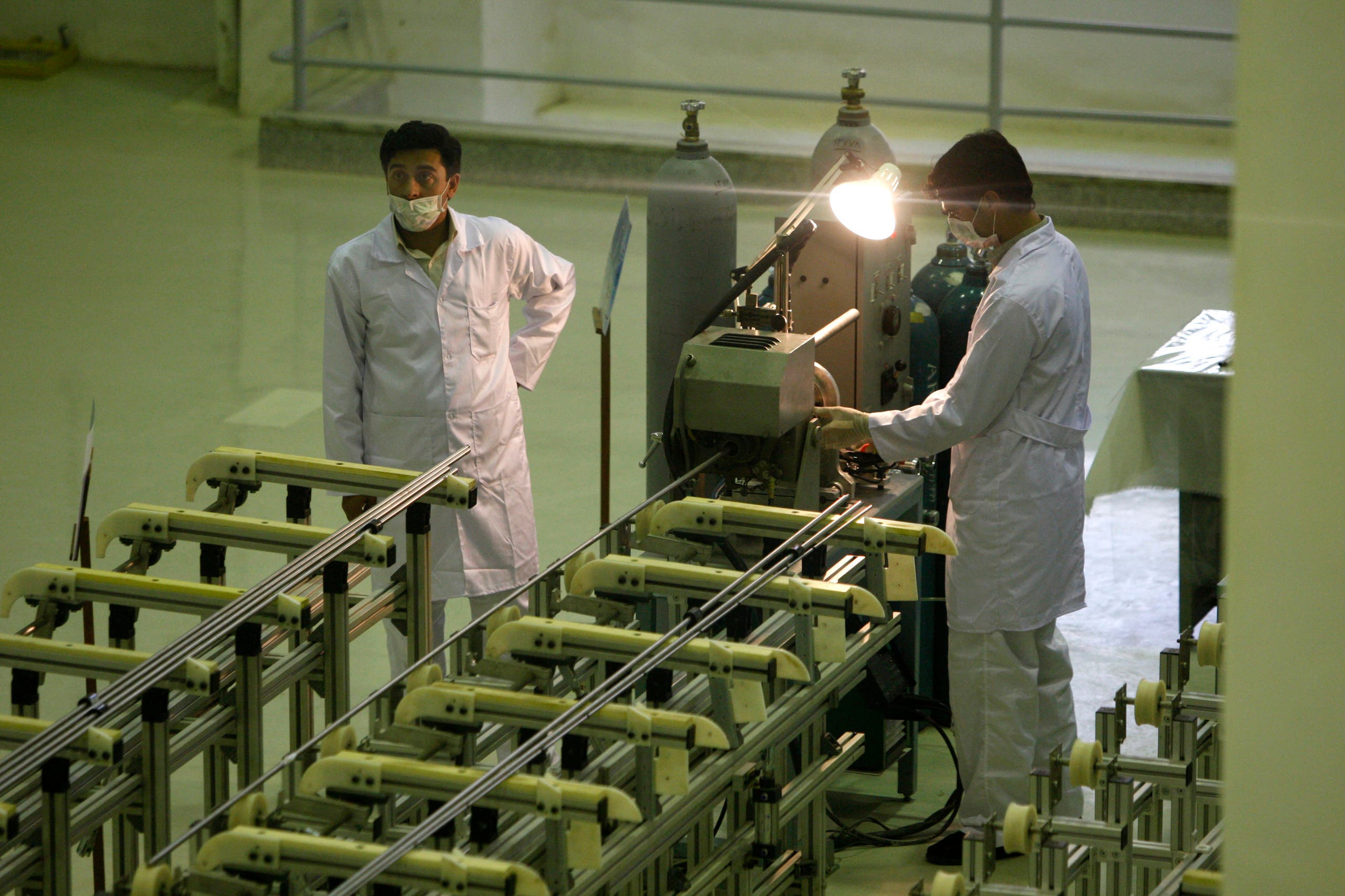 In this April 9, 2009 file photo Iranian technicians work at a new facility producing uranium fuel for a planned heavy-water nuclear reactor, just outside the city of Isfahan, south of Tehran. (AP)