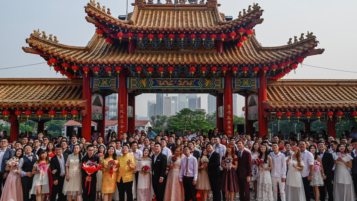 Newly-wed Malaysian couples of Chinese descent pose for photographs during a mass wedding held on the ninth day of the ninth month at the Thean Hou Temple in Kuala Lumpur on September 9, 2019 (AFP)
