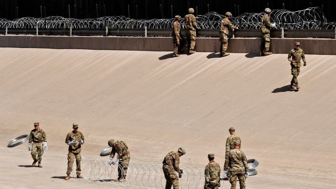 US soldiers install barb wire by the US-Mexico border fence in El Paso, Texas state, US, as seen from Ciudad Juarez, Chihuahua state, Mexico