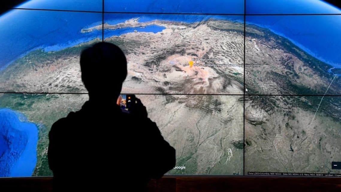 A man looks at a Google Earth map on a screen as Google Earth unveils the revamped version of the application. (AFP)