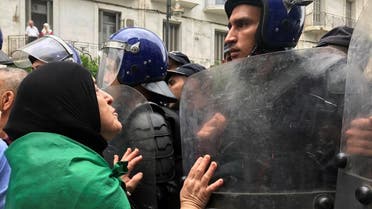 A demonstrator approaches police officers during a protest in Algiers. (Reuters)