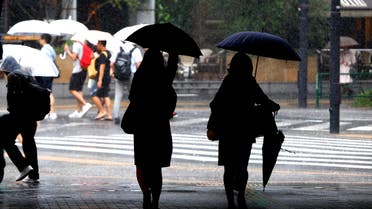 Women holding umbrellas walk in heavy rain at Yurakucho shopping district in Tokyo, Wednesday, Sept. 9, 2015.  (AP)