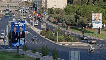 This picture taken on September 16, 2019 shows Israeli election billboards in a street in Jerusalem (L to R) for the Likud party showing US President Donald Trump shaking hands with Likud chairman and Prime Minister Benjamin Netanyahu with a caption in Hebrew reading "Netanyahu, in another league"; and another for the "Blue and White" (Kahol Lavan) electoral alliance showing the face of retired general Benny Gantz and a caption in Hebrew reading "only with the Blue and White will create a united secular government". (AFP)