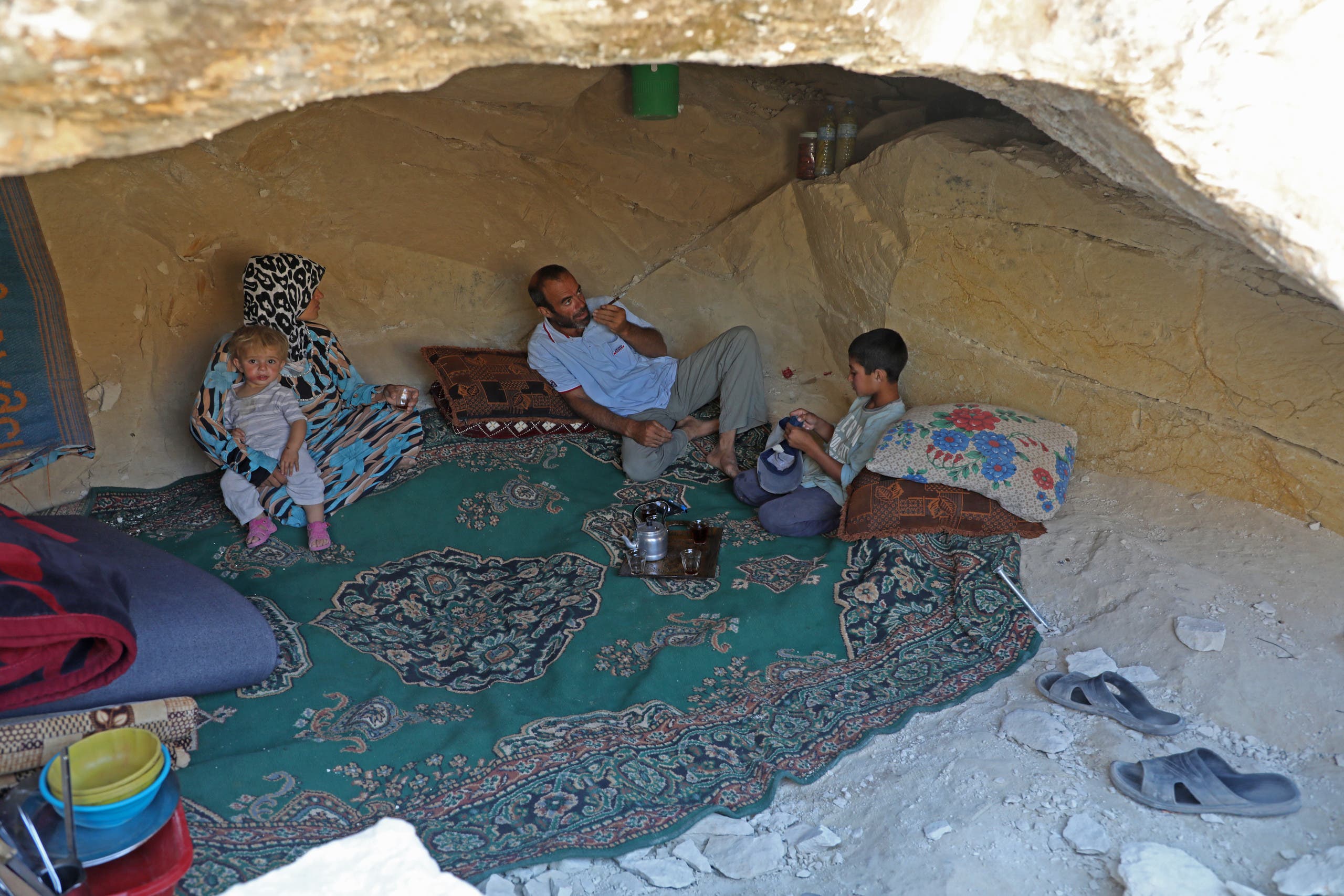 نازحون من إدلب اتخذوا من مغارة مأوى من القصف