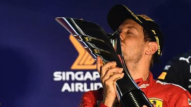 Ferrari's German driver Sebastian Vettel kisses the trophy on the podium after winning the Formula One Singapore Grand Prix night race at the Marina Bay Street Circuit in Singapore on September 22, 2019. (AFP)