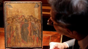 Art expert Eric Turquin inspects the painting "Christ Mocked", a long-lost masterpiece by Florentine Renaissance artist Cimabue in the late 13th century, which was found months ago hanging in an elderly woman's kitchen in the town of Compiegne, displayed in Paris, France, September 24, 2019. REUTERS