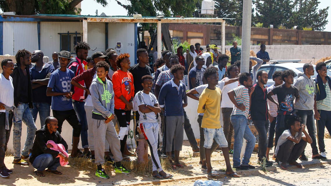 Rescued migrants sit on the coast of Khoms, some 100 kilometres (60 miles) from the Libyan capital Tripoli, on July 26, 2019. More than 100 migrants were missing after their boat sank off the coast of Libya in what might be the worst tragedy in the Mediterranean this year, aid agencies said. About 145 migrants were rescued by the Libyan coastguard, and survivors had reported that about 150 people remained missing.