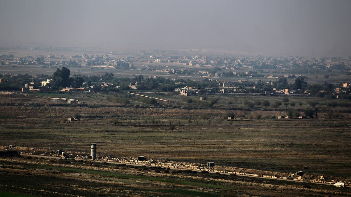 (FILES) A picture taken on November 12, 2018 from al-Qaim in Iraq's border al-Anbar province shows the Syrian border city of Albu Kamal in the Deir Ezzor region. Air strikes hit positions of pro-Iranian forces and allied militias in eastern Syria overnight, killing 18 fighters, a war monitor said today.