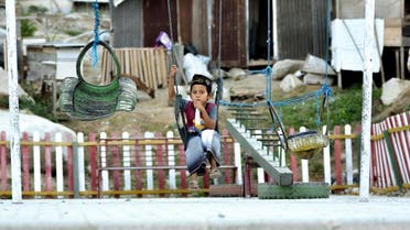 his picture taken on September 25, 2019 shows 9-year-old Rafi Adit Putra sitting on a swing near his living place, a temporary shelter, in Palu, Central Sulawesi. (AFP)