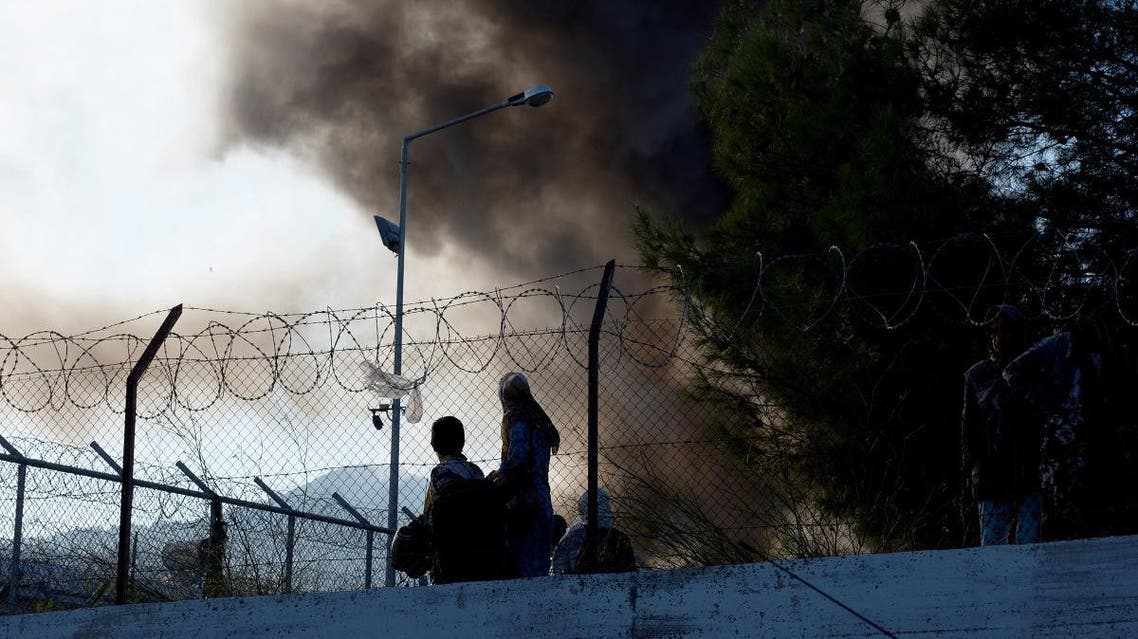 Refugees and migrants try to escape the camp of Moria after a fire broke out in the camp in Mytilene on September 29, 2019. (AFP)